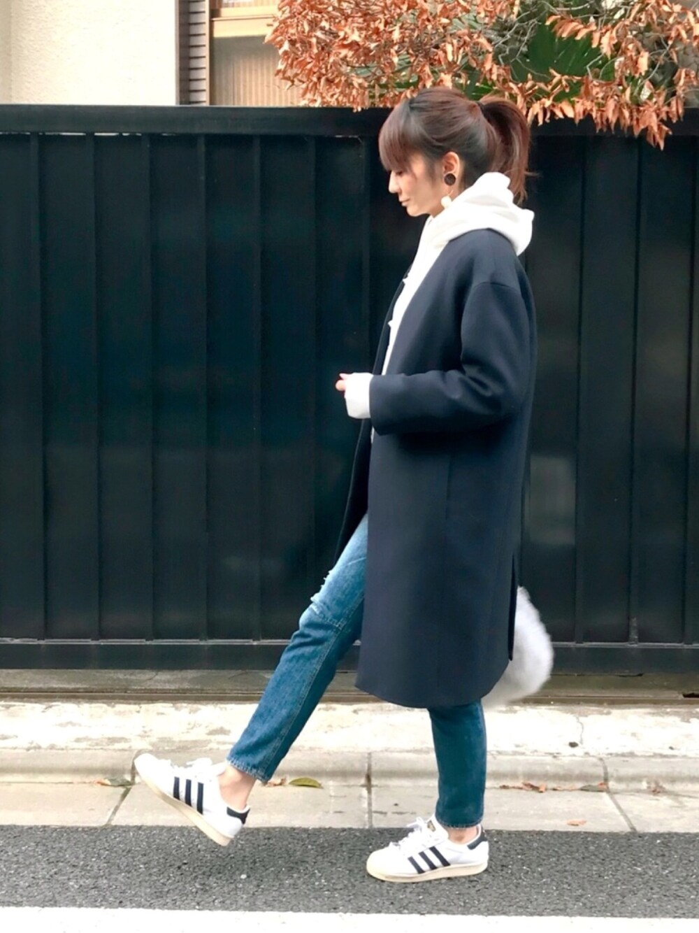 ホワイト系のパーカー、ブルー系のその他アウター、ブルー系のデニムパンツを着用したレディースの冬コーディネートの1枚目の写真