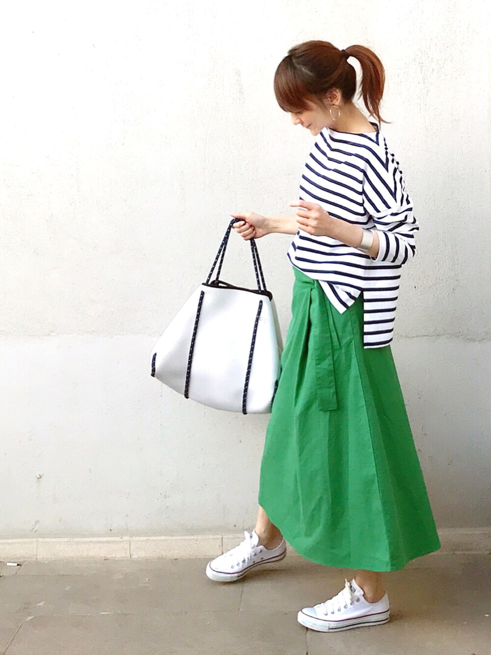 グリーン系のスカート、ブルー系のTシャツ/カットソー、ホワイト系のスニーカーを着用したレディースの夏コーディネートの1枚目の写真