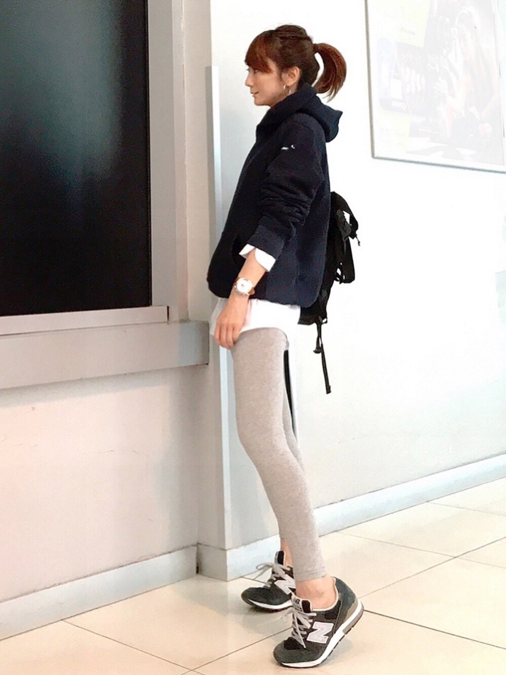 ブルー系のパーカー、ブルー系のスニーカー、ブラック系のトートバッグを着用したレディースの冬コーディネートの1枚目の写真