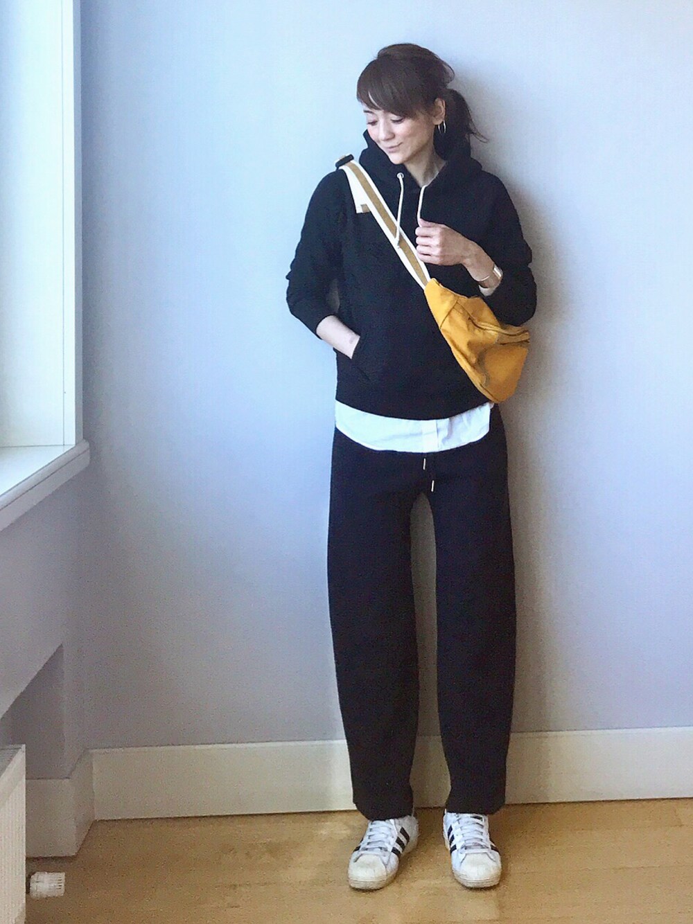 イエロー系のボディバッグ/ウエストポーチ、ブルー系のワンピース、ブルー系のパーカーを着用したレディースの春コーディネートの1枚目の写真