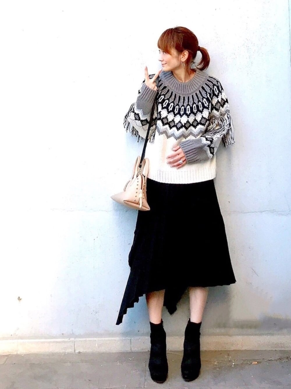 ブラック系のブーツ、ホワイト系のニット/セーター、ブラック系のスカートを着用したレディースの秋コーディネートの1枚目の写真