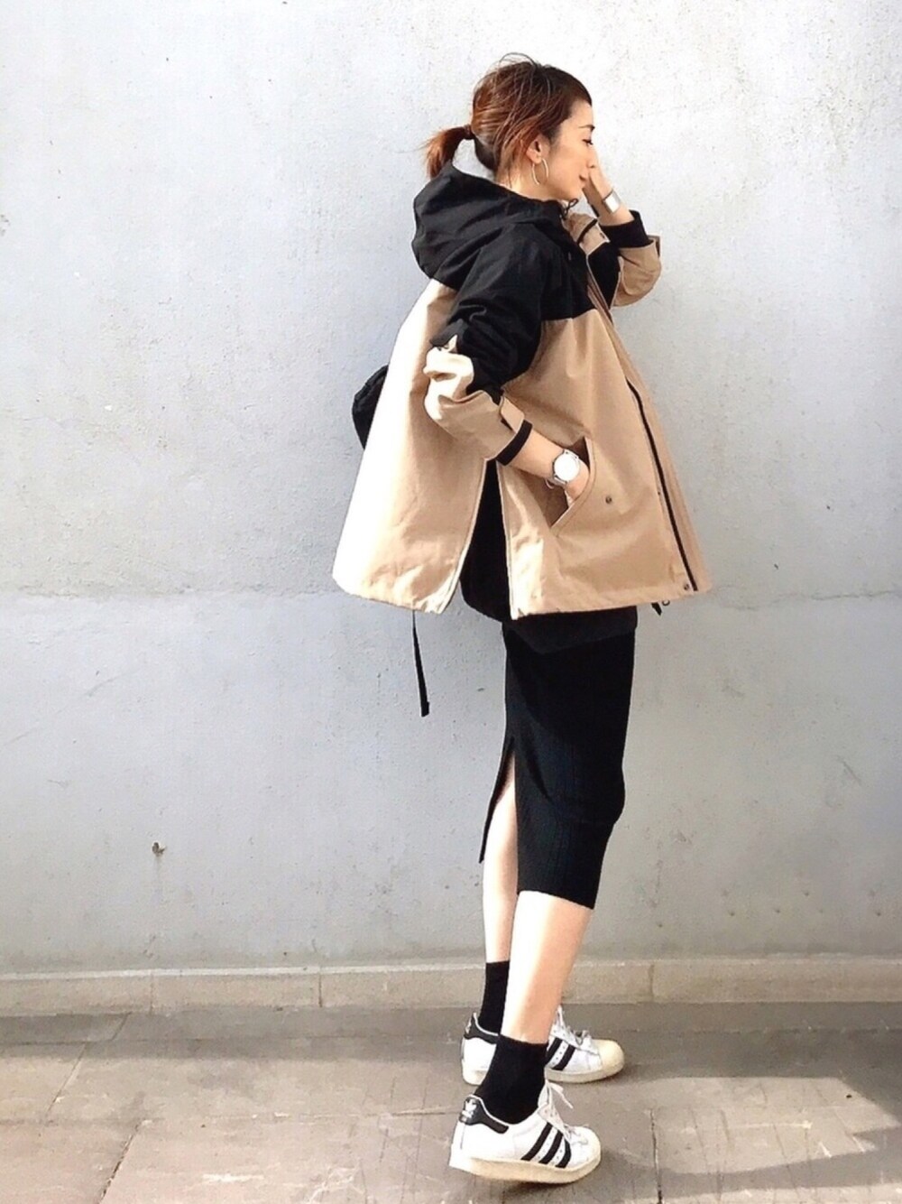 ベージュ系のブルゾン、ブラック系のスカート、ホワイト系のスニーカーを着用したレディースの秋コーディネートの1枚目の写真
