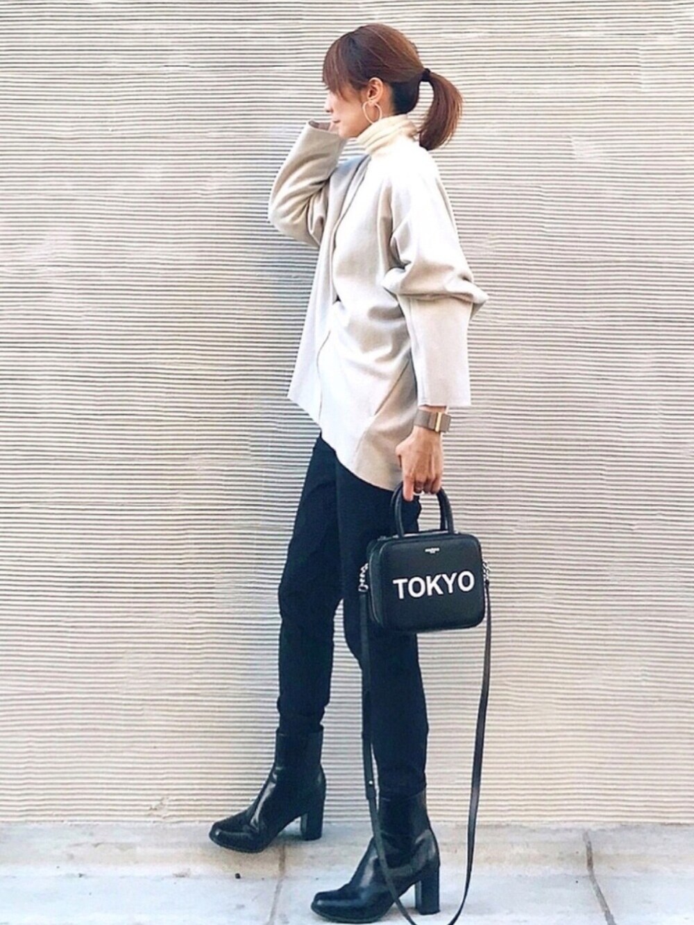 ベージュ系のTシャツ/カットソー、ブラック系のハンドバッグ、ブラック系のブーツを着用したレディースの冬コーディネートの1枚目の写真