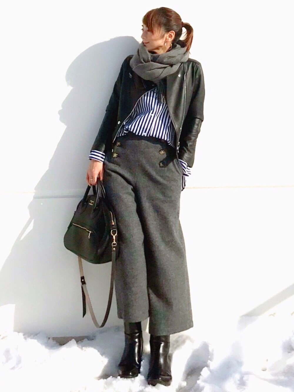 ブラック系のブーツ、ブラック系のライダースジャケット、ブラック系のショルダーバッグを着用したレディースの冬コーディネートの1枚目の写真