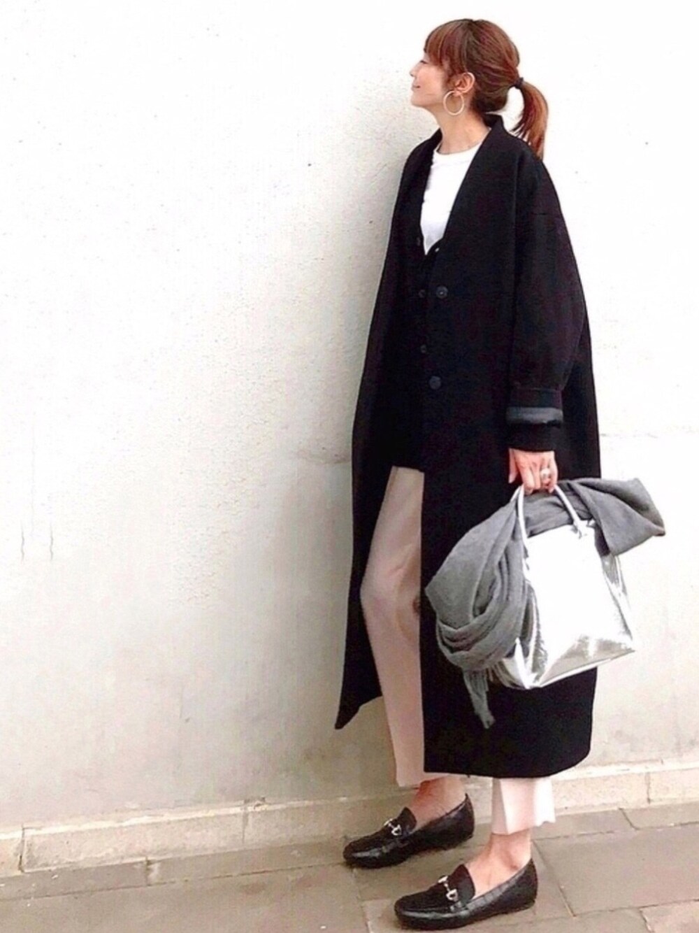 ブラック系のローファー、ブラック系のニット/セーター、ホワイト系のTシャツ/カットソーを着用したレディースの冬コーディネートの1枚目の写真