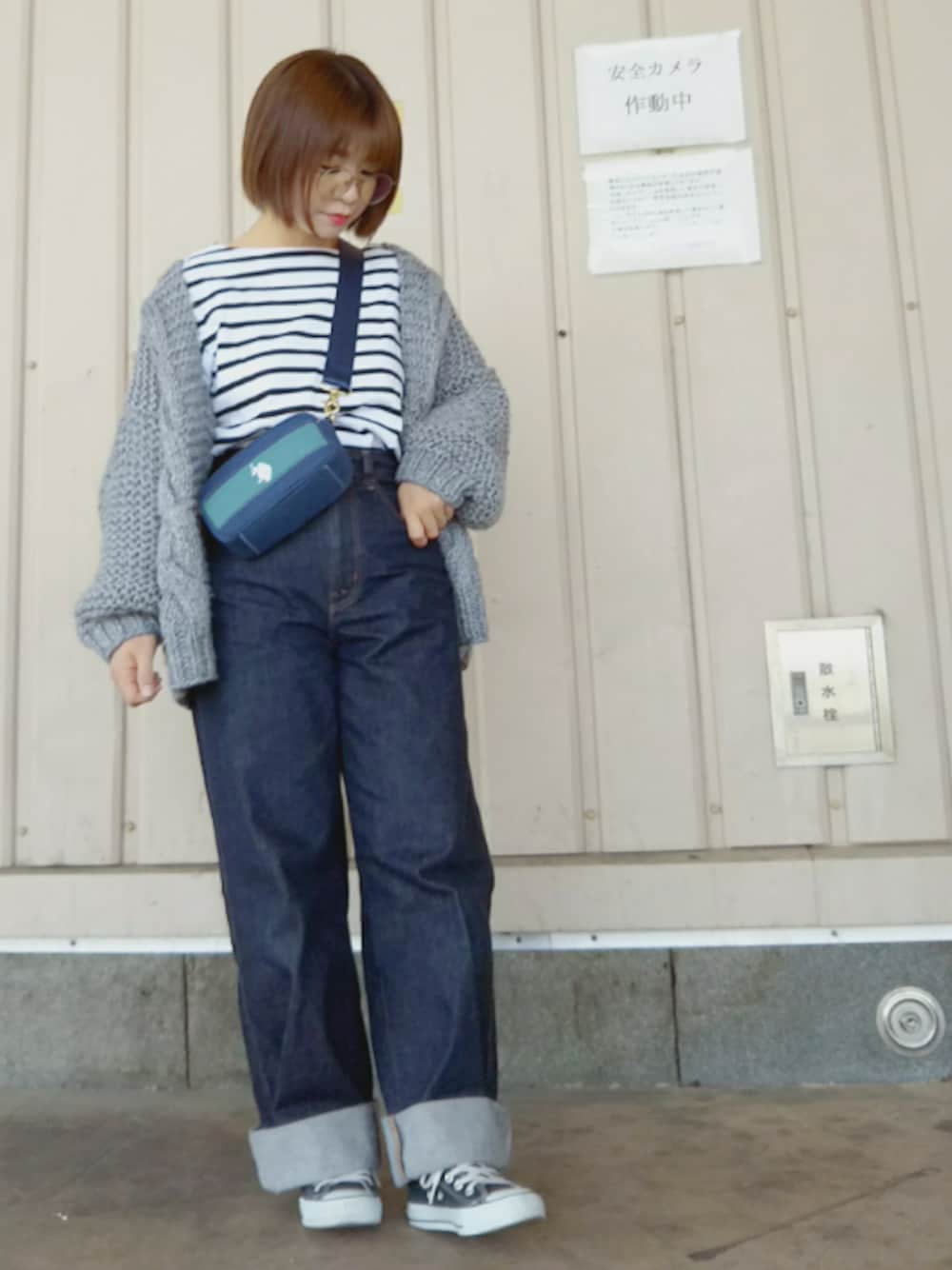 グレー系のカーディガン/ボレロ、グリーン系のショルダーバッグ、ブルー系のデニムパンツを着用したレディースの春コーディネートの1枚目の写真