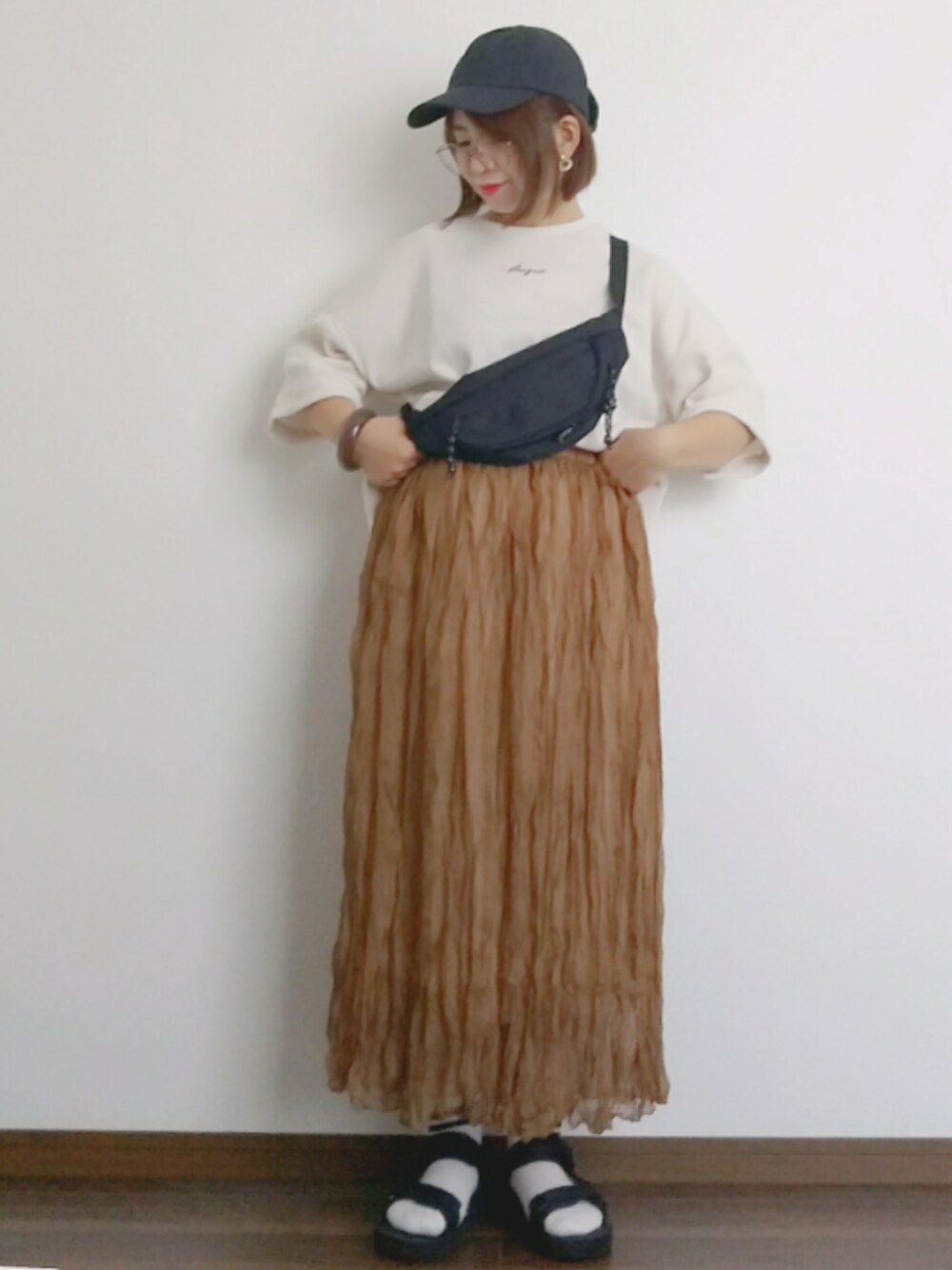 ホワイト系のTシャツ/カットソー、ブラウン系のスカート、ブラック系のサンダルを着用したレディースの春コーディネートの1枚目の写真