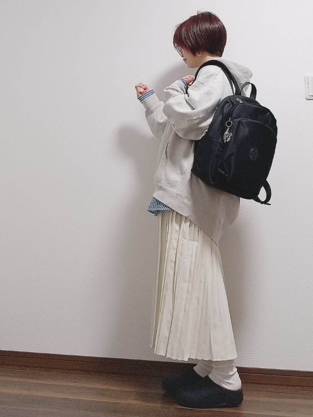 ブラック系のバックパック/リュック、ブルー系のシャツ/ブラウス、ホワイト系のスカートを着用したレディースの春コーディネートの1枚目の写真