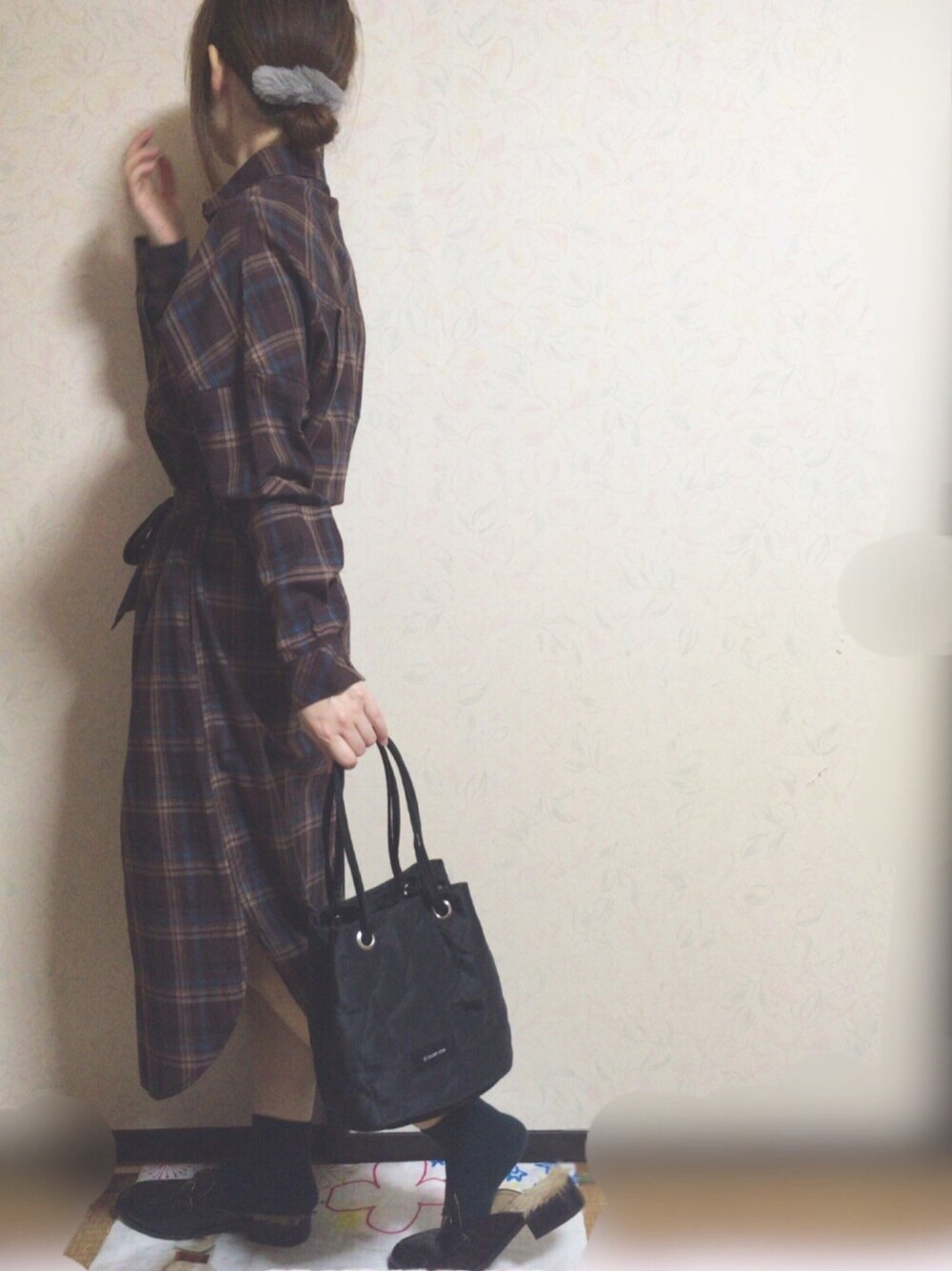 ブラウン系のワンピース、ブラック系のハンドバッグを着用したレディースの秋コーディネートの1枚目の写真