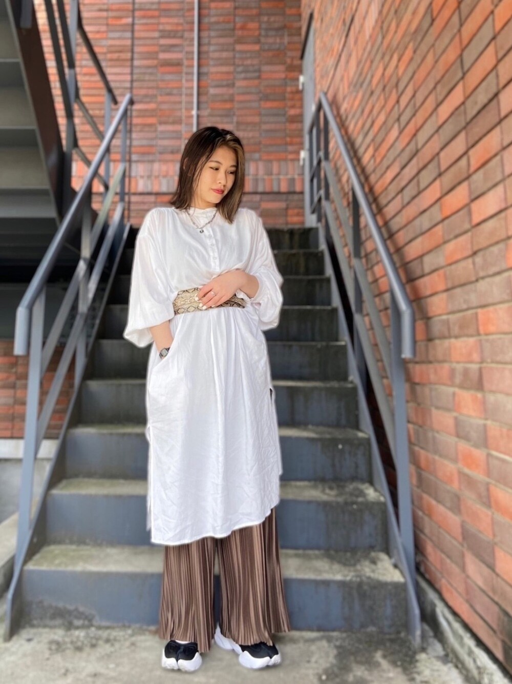 ホワイト系のシャツワンピース、ブラウン系のその他パンツを着用したレディースの春コーディネートの1枚目の写真