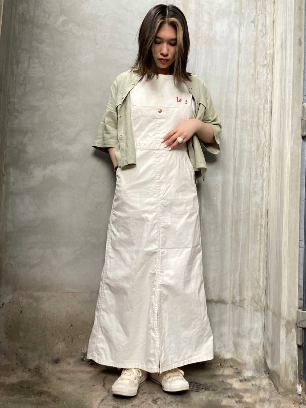 ホワイト系のジャンパースカート、グリーン系のシャツ/ブラウス、ホワイト系のTシャツ/カットソーを着用したレディースの春コーディネートの1枚目の写真