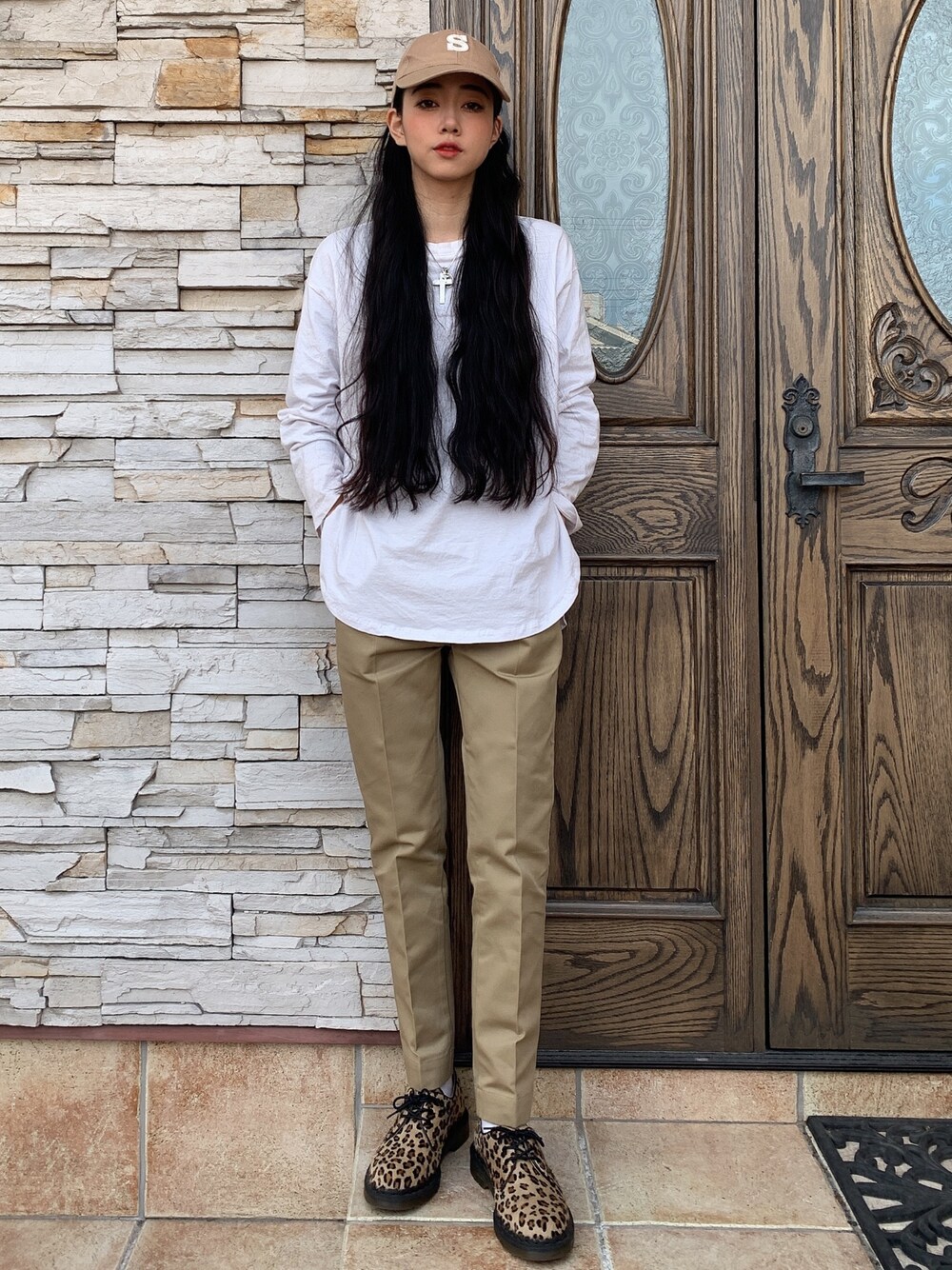 ベージュ系のパンツ、ブラウン系のシューズ、ベージュ系の帽子を着用したレディースの冬コーディネートの1枚目の写真