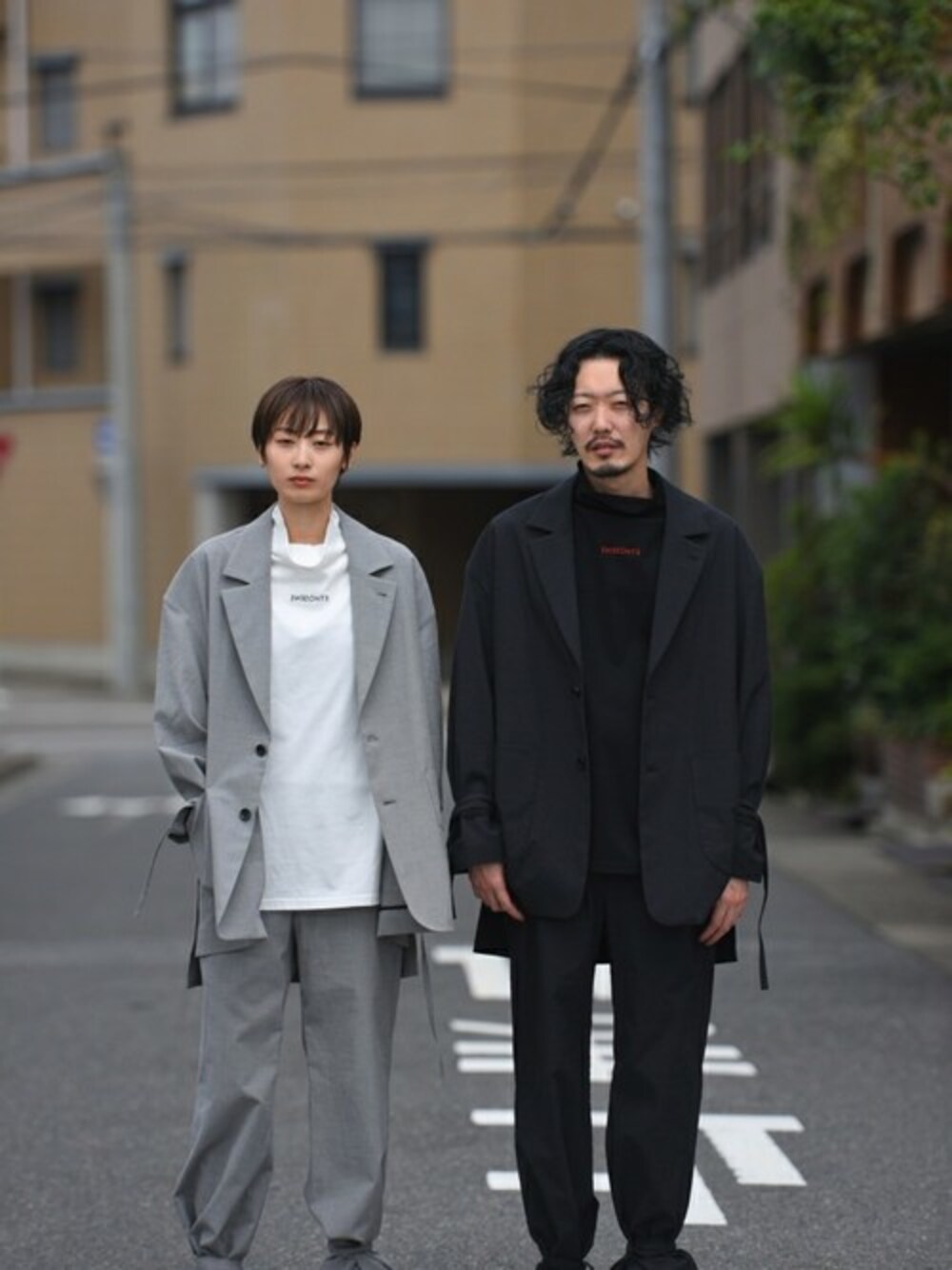 ホワイト系のスラックス、ホワイト系のテーラードジャケット、ブラック系のスラックスを着用したレディースの冬コーディネートの1枚目の写真