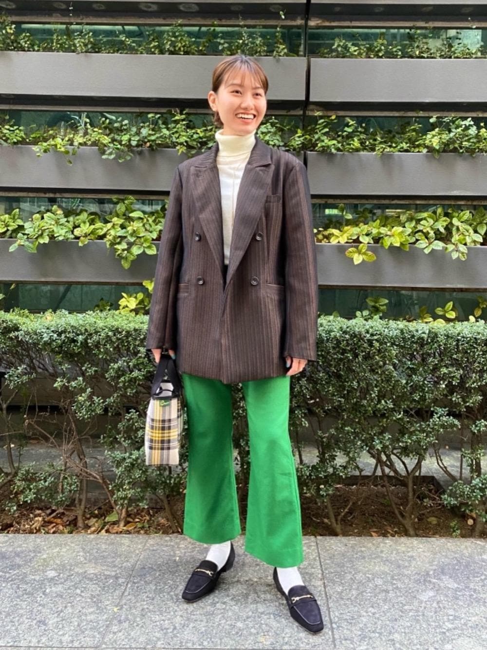 イエロー系のトートバッグ、ブラック系のローファーを着用したレディースの秋コーディネートの1枚目の写真