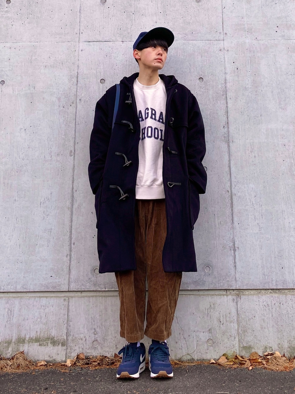 ブルー系のダッフルコート、ホワイト系のスウェット、ブルー系のショルダーバッグを着用したメンズの秋コーディネートの1枚目の写真