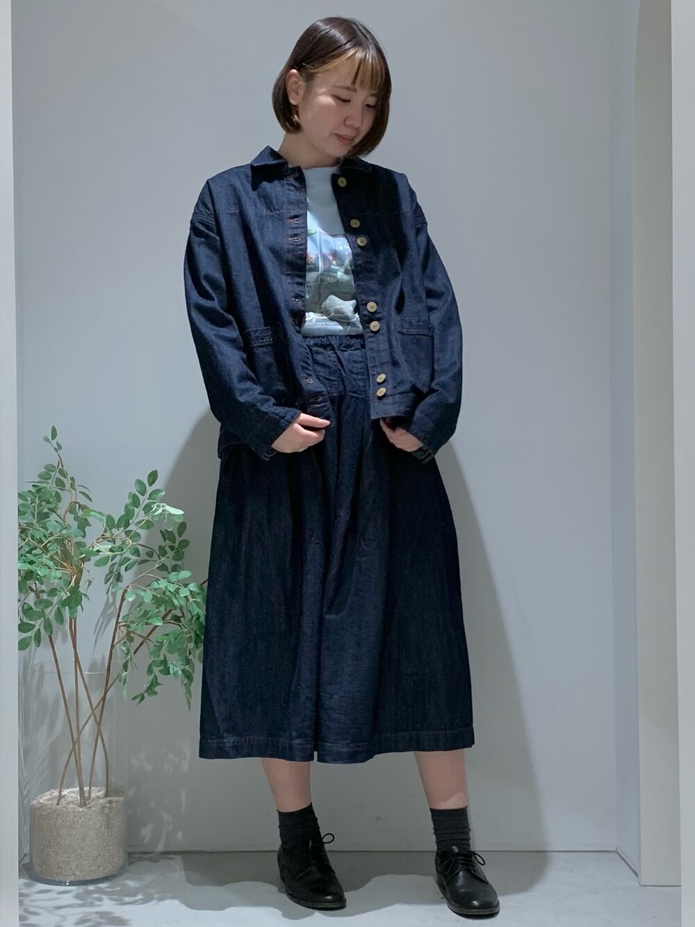 ブルー系のデニムジャケット、ブルー系のデニムスカート、ブルー系のTシャツ/カットソーを着用したレディースの冬コーディネートの1枚目の写真