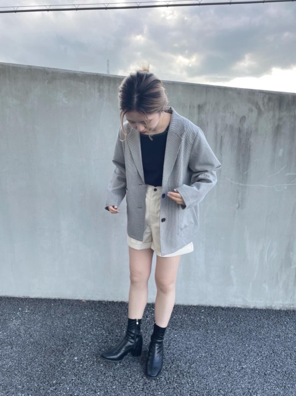 ブラック系のニット/セーター、ブラック系のブーツ、レッド系のテーラードジャケットを着用したレディースの秋コーディネートの1枚目の写真