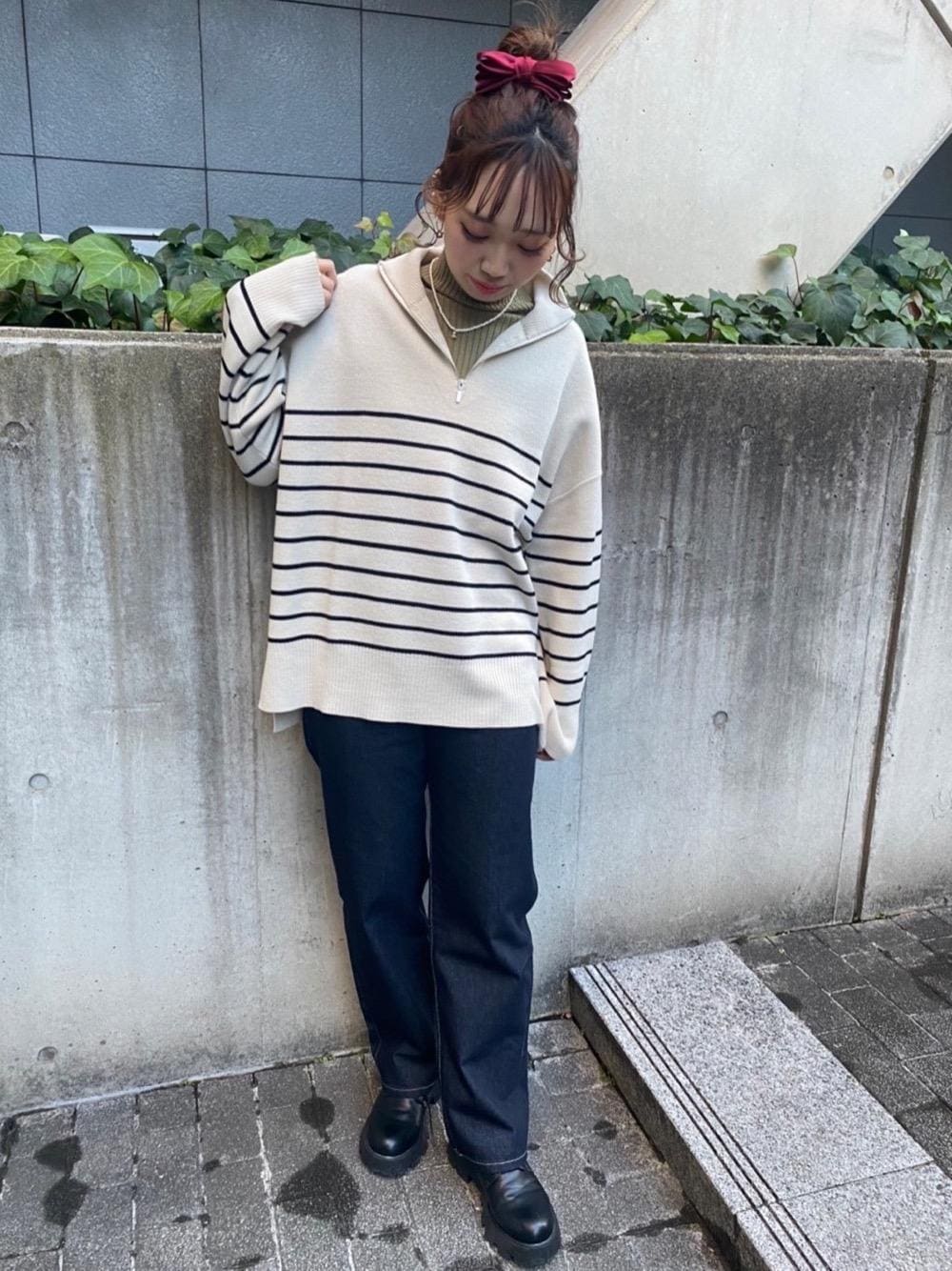 グリーン系のTシャツ/カットソー、ブルー系のデニムパンツ、ホワイト系のニット/セーターを着用したレディースの春コーディネートの1枚目の写真