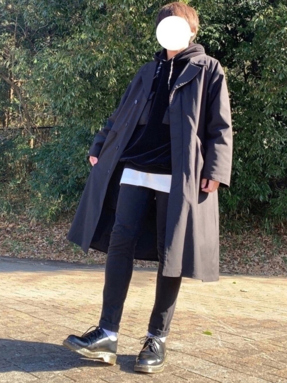 ブラック系のチェスターコート、ブラック系のパーカー、ホワイト系のTシャツ/カットソーを着用したメンズの冬コーディネートの1枚目の写真