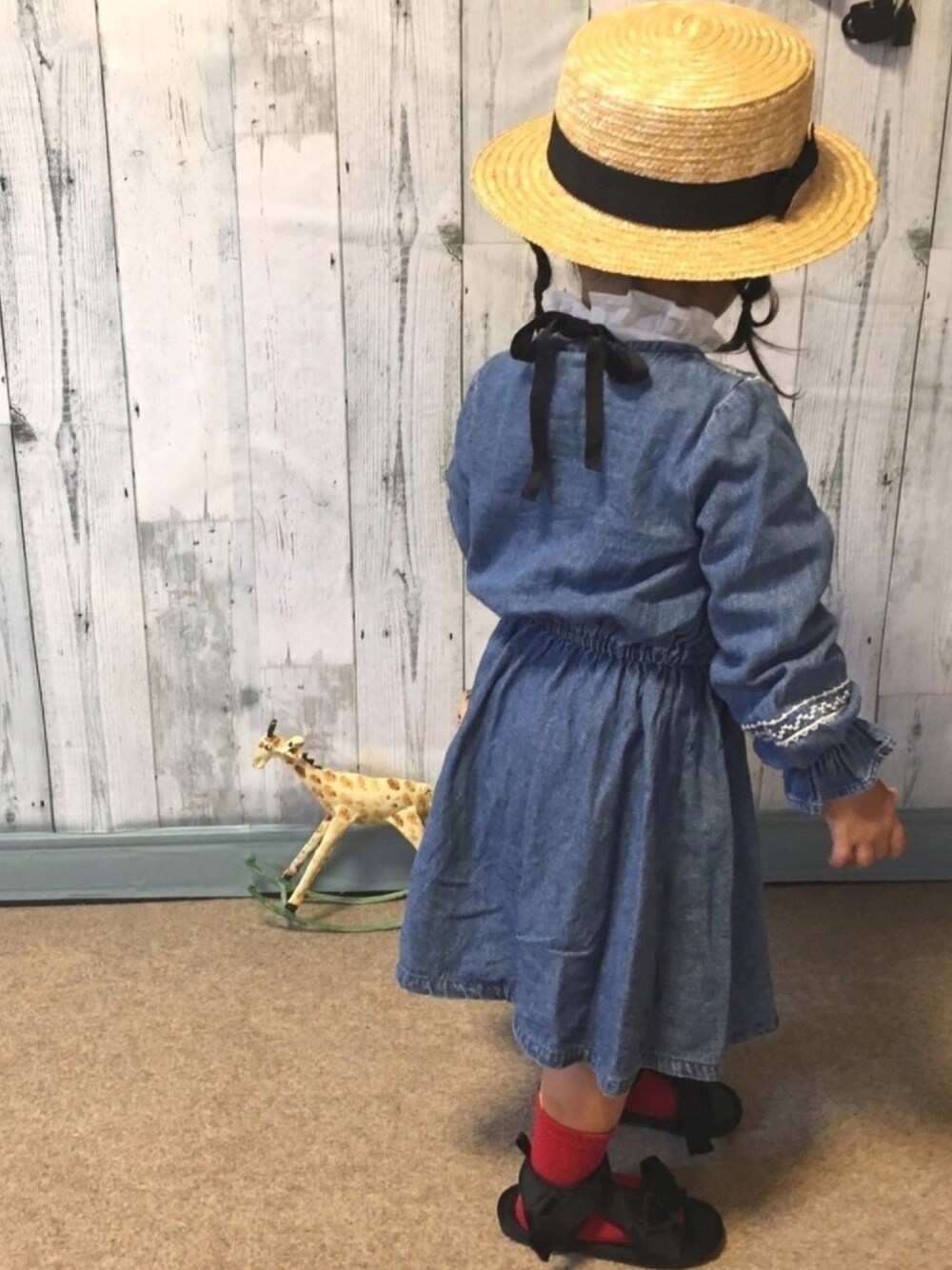 ブルー系のワンピース、ブラック系のサンダル、ベージュ系のハットを着用したキッズの春コーディネートの1枚目の写真