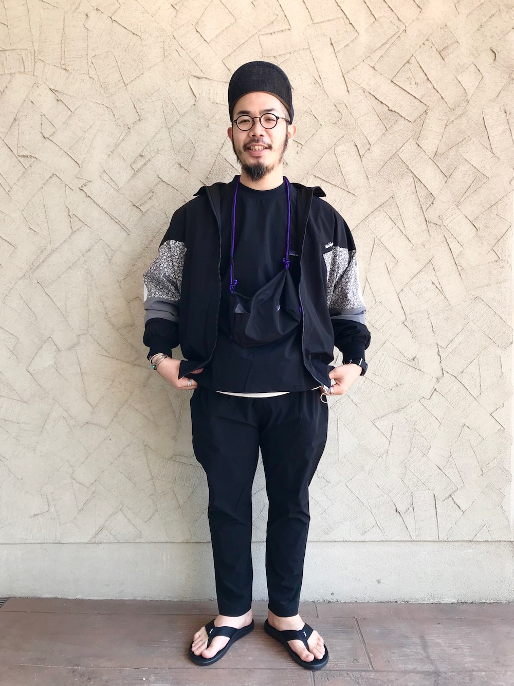 ブラック系のブルゾン、ブラック系のTシャツ/カットソー、ブラック系のサンダルを着用したメンズの春コーディネートの1枚目の写真