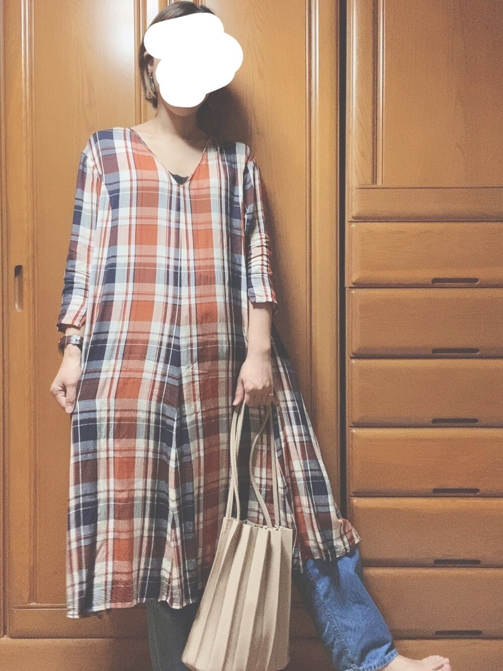 ブラウン系のワンピース、ブルー系のデニムパンツ、ホワイト系のトートバッグを着用したレディースの秋コーディネートの1枚目の写真