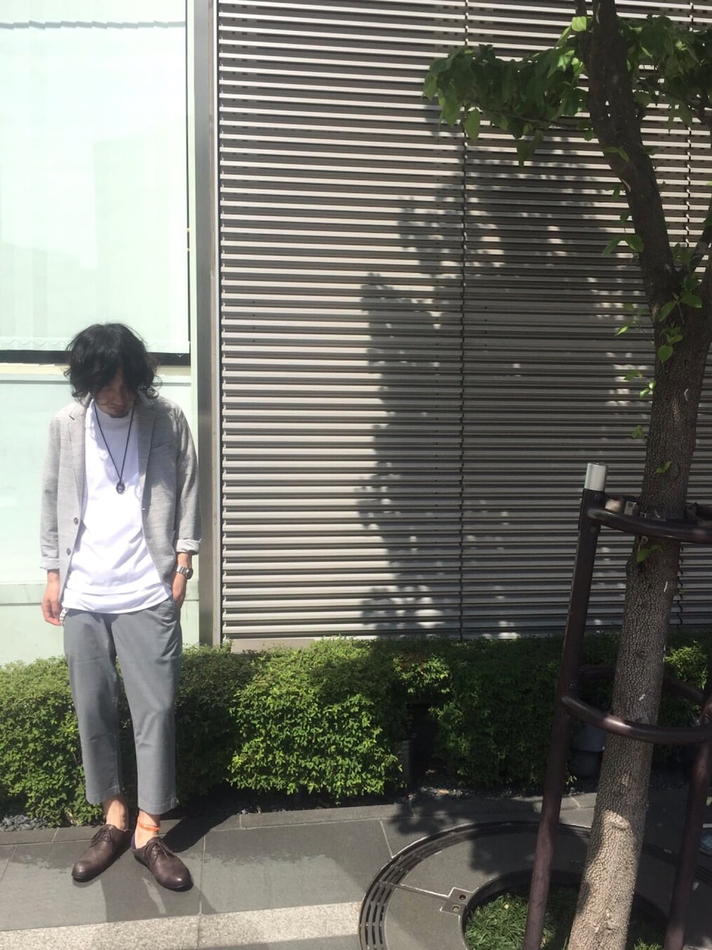 グレー系のテーラードジャケット、ホワイト系のTシャツ/カットソー、ホワイト系のタンクトップを着用したメンズの春コーディネートの1枚目の写真