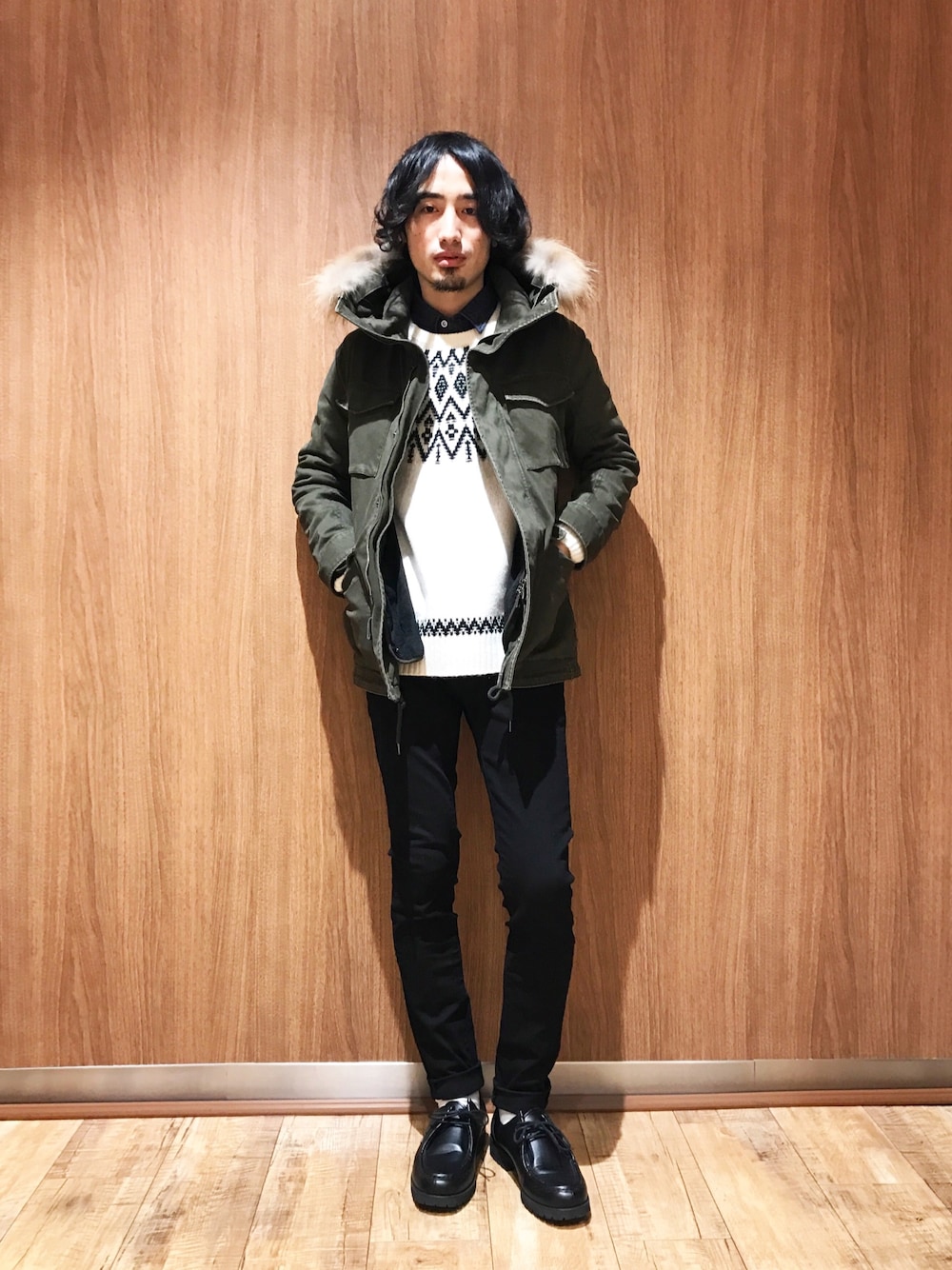 グリーン系のミリタリージャケット、ホワイト系のニット/セーター、ブラック系のデニムパンツを着用したメンズの秋コーディネートの1枚目の写真