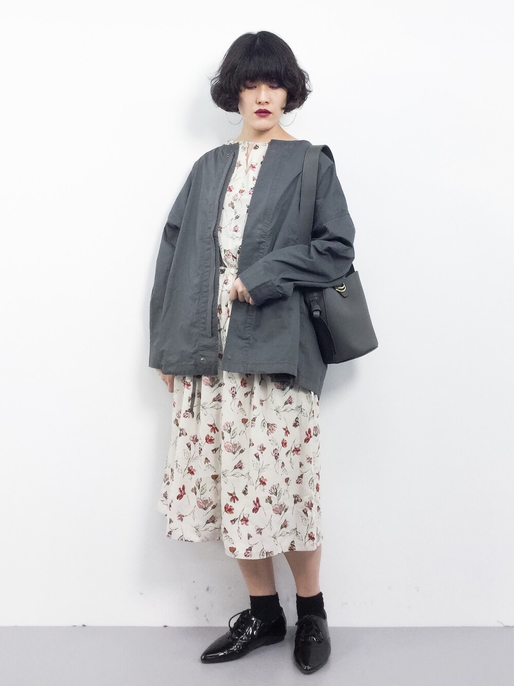 ブラック系のブルゾン、グレー系のショルダーバッグを着用したレディースの春コーディネートの1枚目の写真