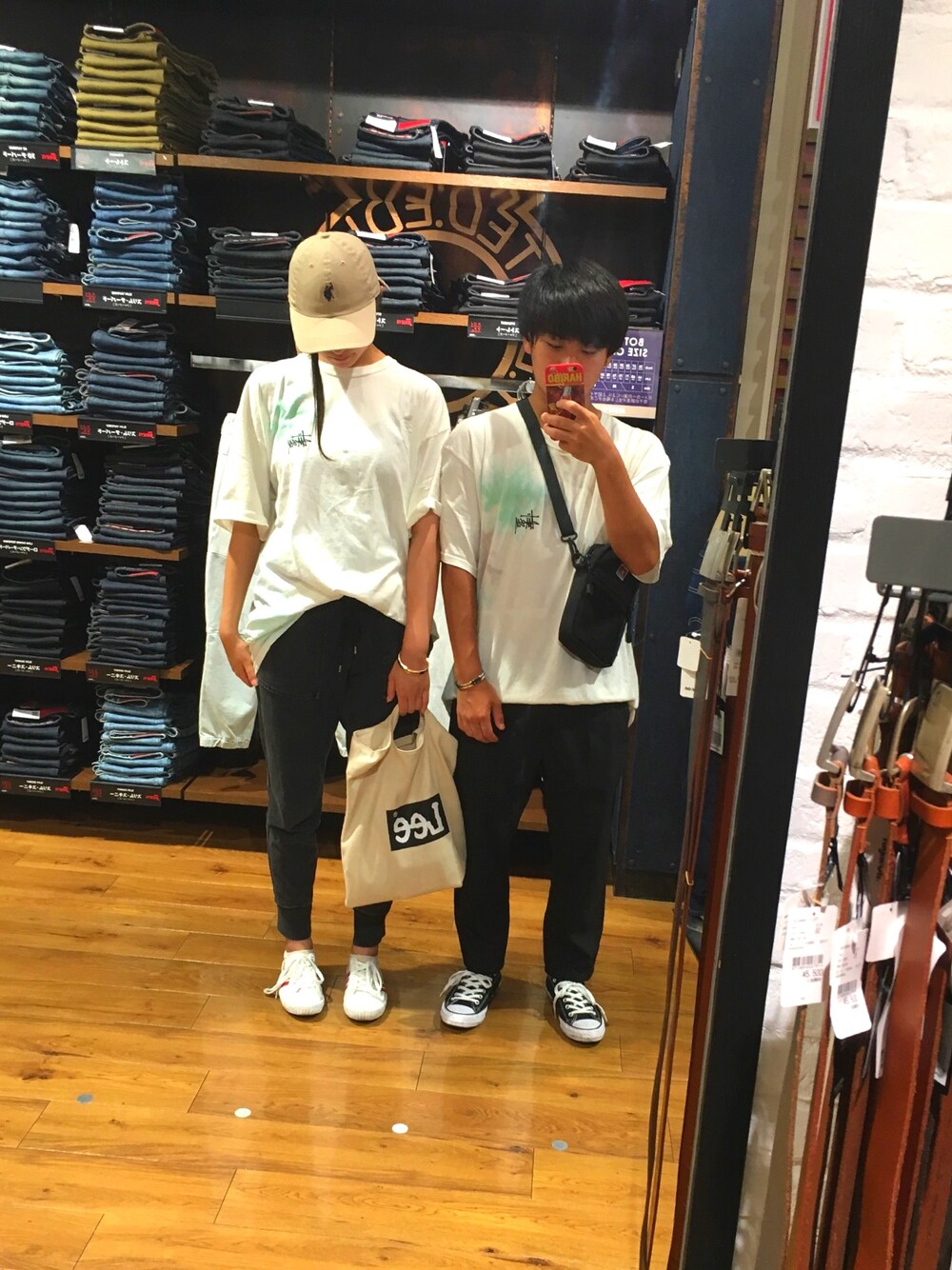 ホワイト系のスニーカー、ブラック系のスラックス、ベージュ系のTシャツ/カットソーを着用したメンズの夏コーディネートの1枚目の写真