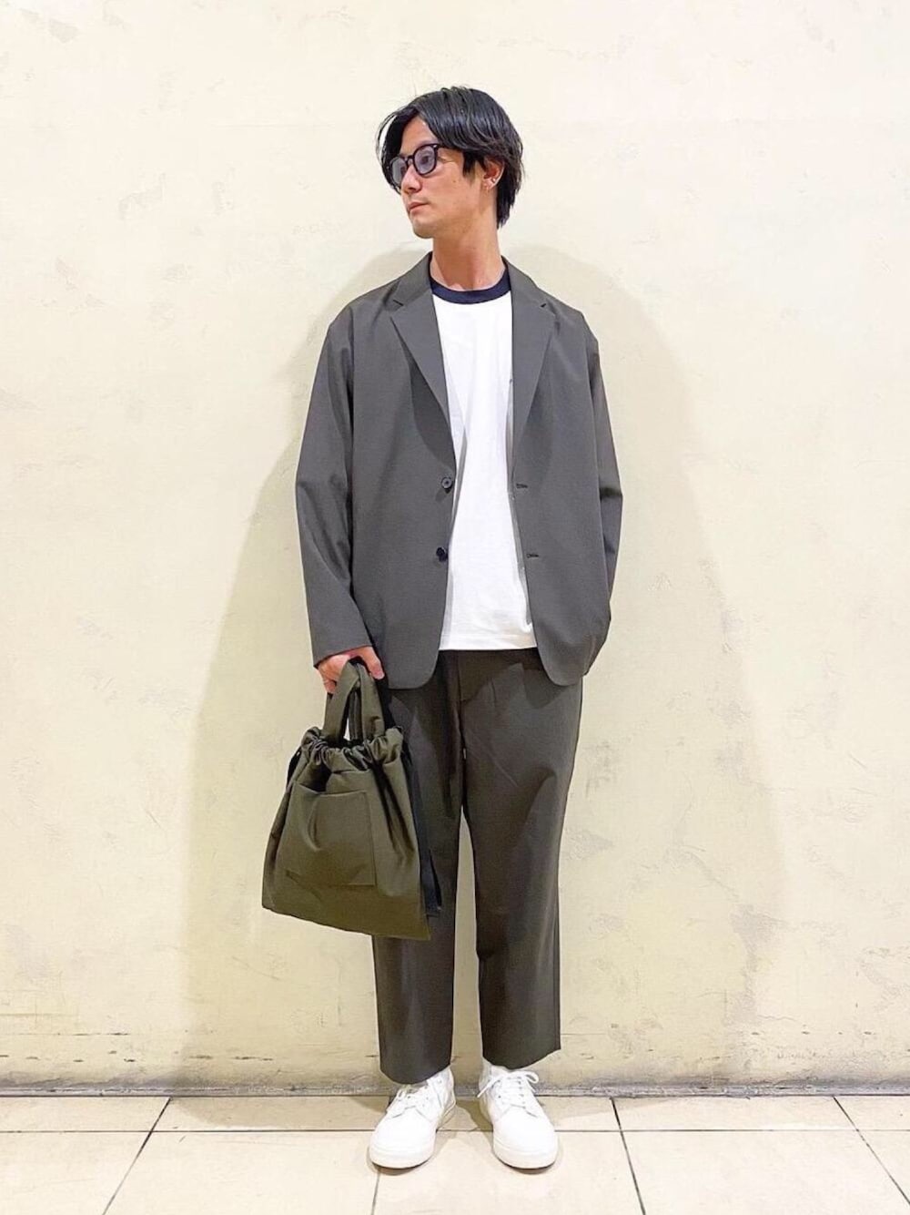 ホワイト系のスニーカー、ホワイト系のTシャツ/カットソー、グリーン系のテーラードジャケットを着用したメンズの春コーディネートの1枚目の写真