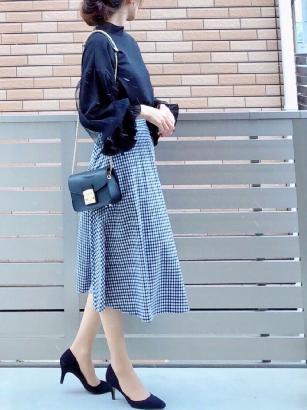 ブラック系のシャツ/ブラウス、ブルー系のスカート、ブラック系のショルダーバッグを着用したレディースの冬コーディネートの1枚目の写真