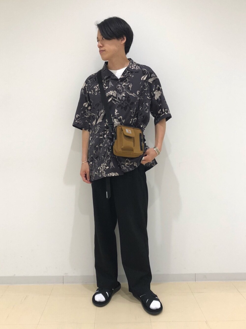 ブラック系のスラックス、グレー系のシャツ/ブラウス、ブラウン系のショルダーバッグを着用したメンズの夏コーディネートの1枚目の写真