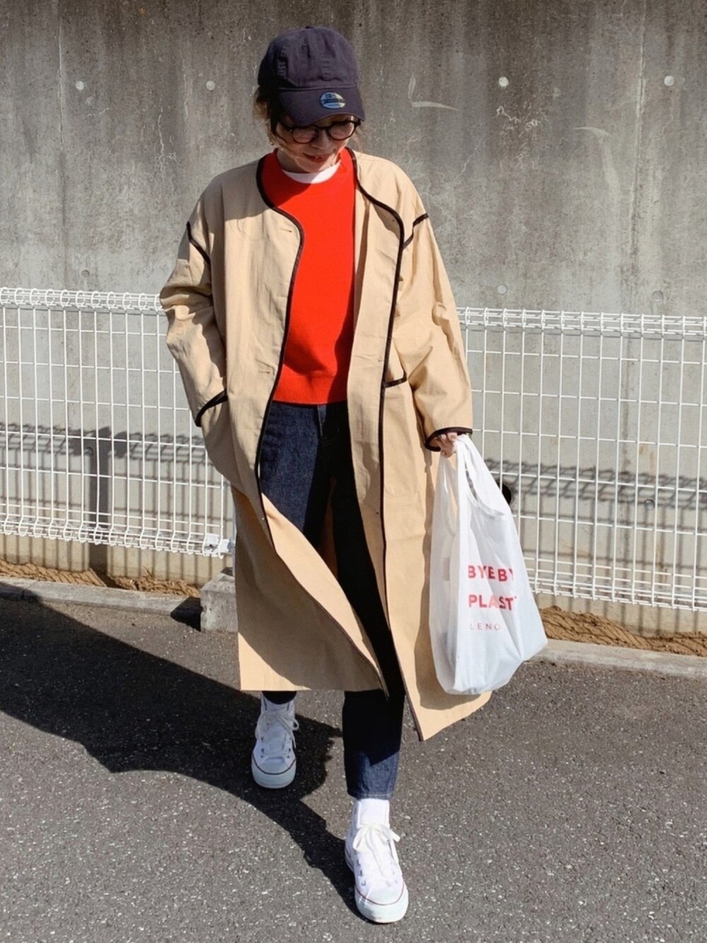 ブルー系のデニムパンツ、ホワイト系のバッグ、ホワイト系のスニーカーを着用したレディースの冬コーディネートの1枚目の写真