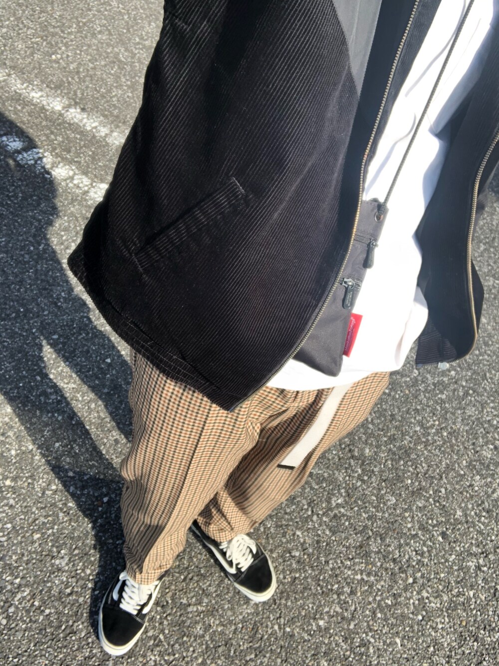 ブラック系のその他アウター、ホワイト系のTシャツ/カットソー、ブラック系のスニーカーを着用したメンズの秋コーディネートの1枚目の写真