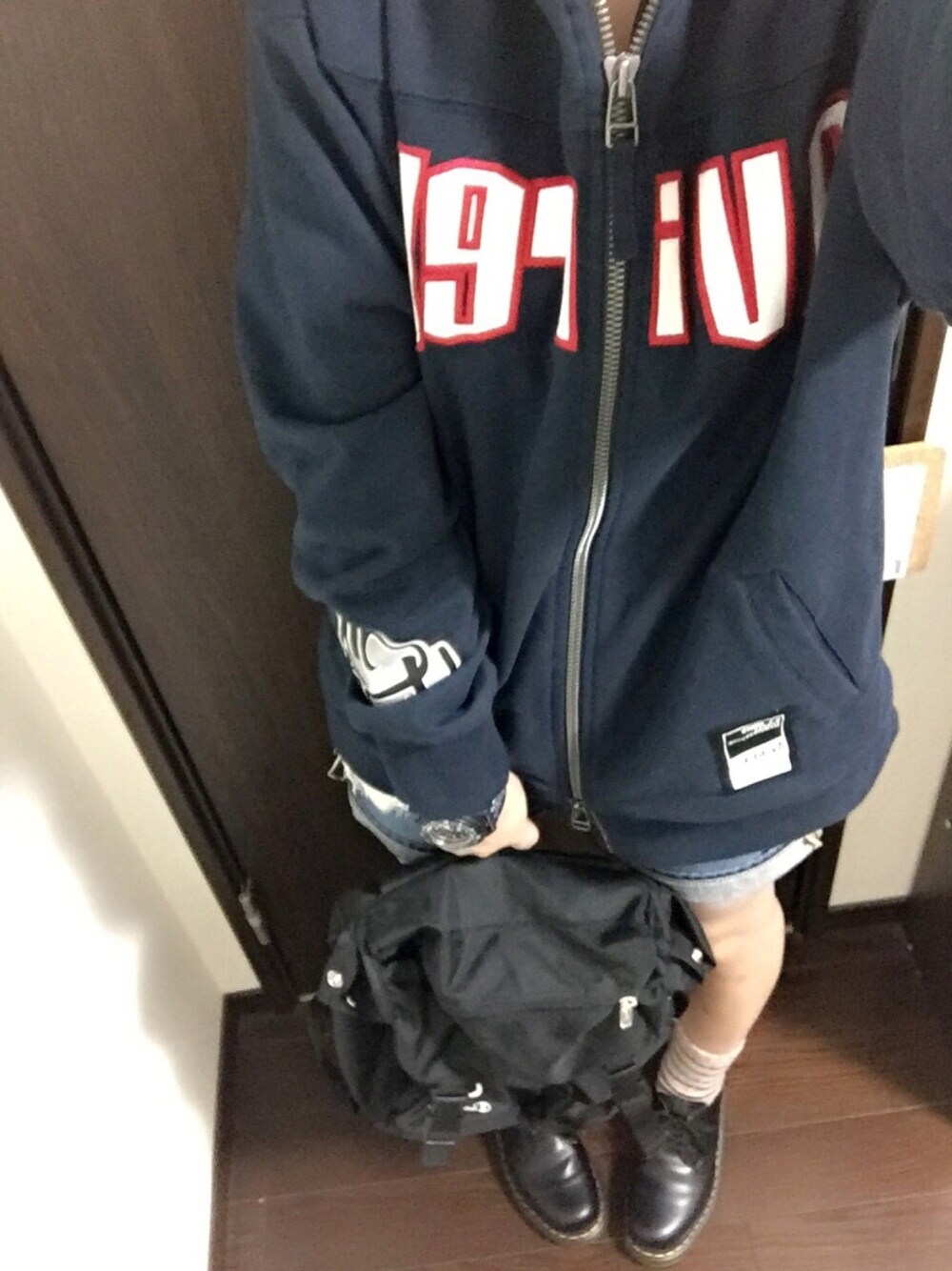 ブルー系のパーカー、ブルー系のデニムパンツ、ブラック系のドレスシューズを着用したレディースの春コーディネートの1枚目の写真