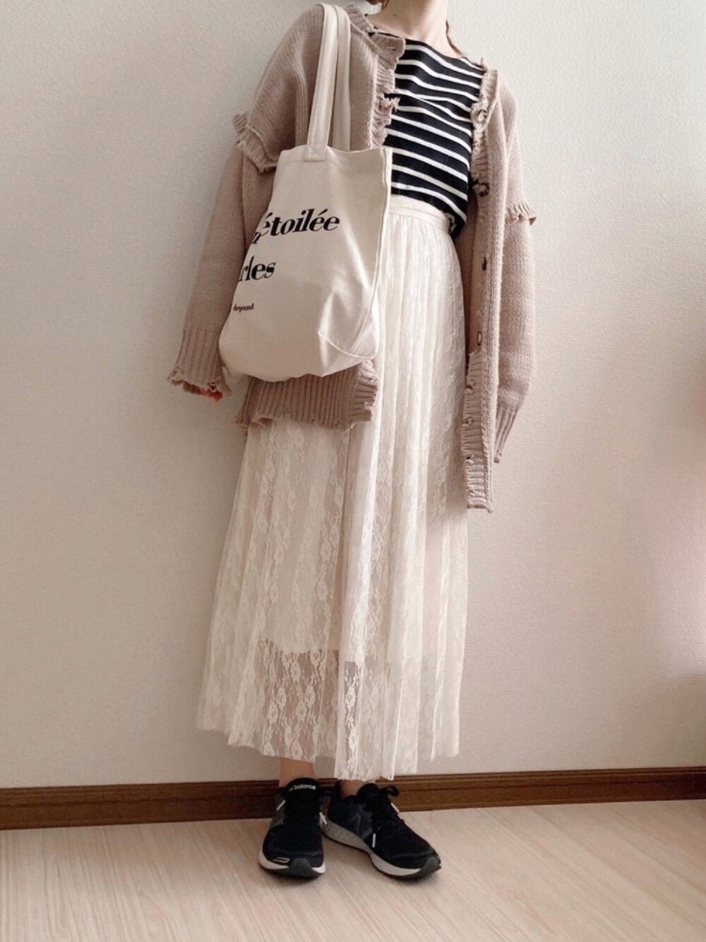 ホワイト系のスカート、ブラック系のTシャツ/カットソー、ホワイト系のトートバッグを着用したレディースの春コーディネートの1枚目の写真