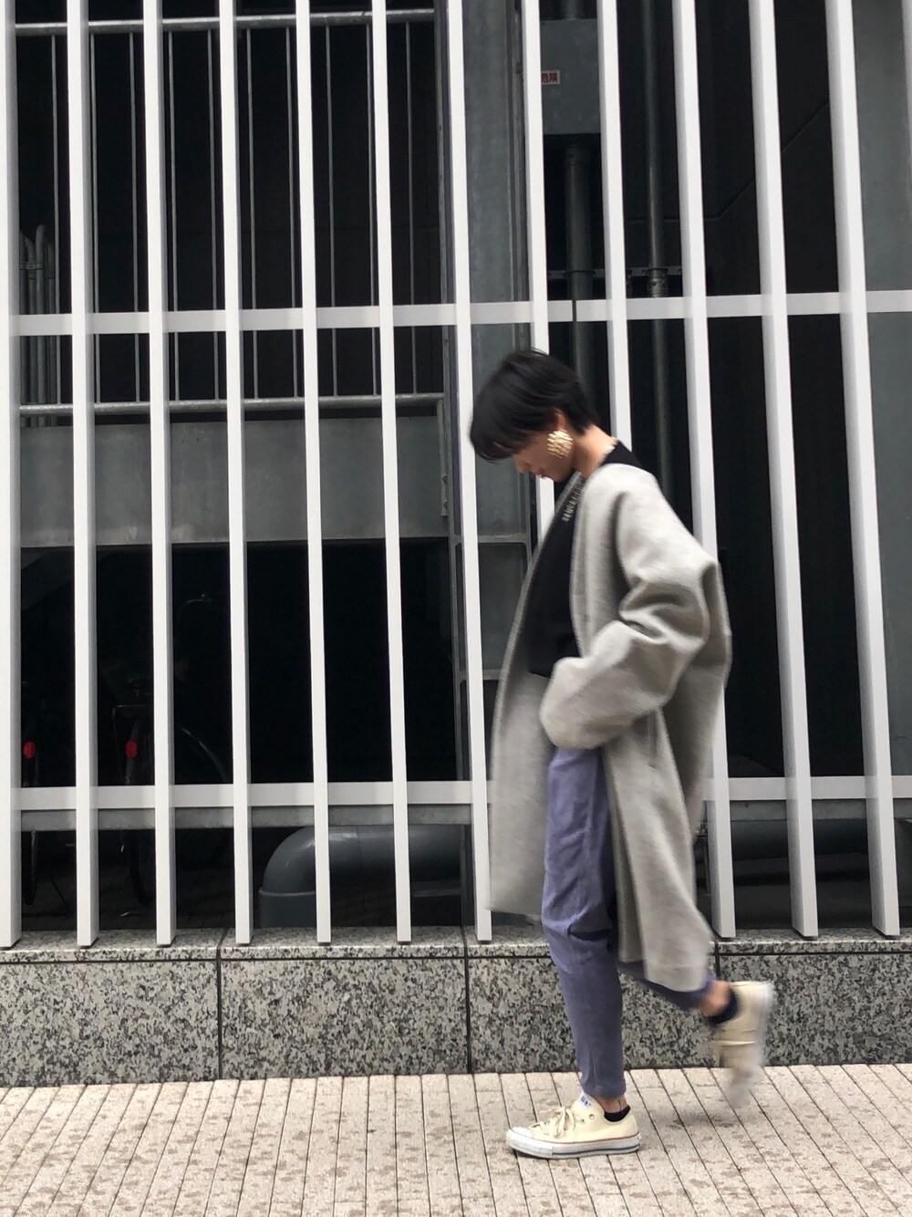 ブラウン系のノーカラーコート、ベージュ系のニット/セーター、ブルー系のその他パンツを着用したレディースの冬コーディネートの1枚目の写真