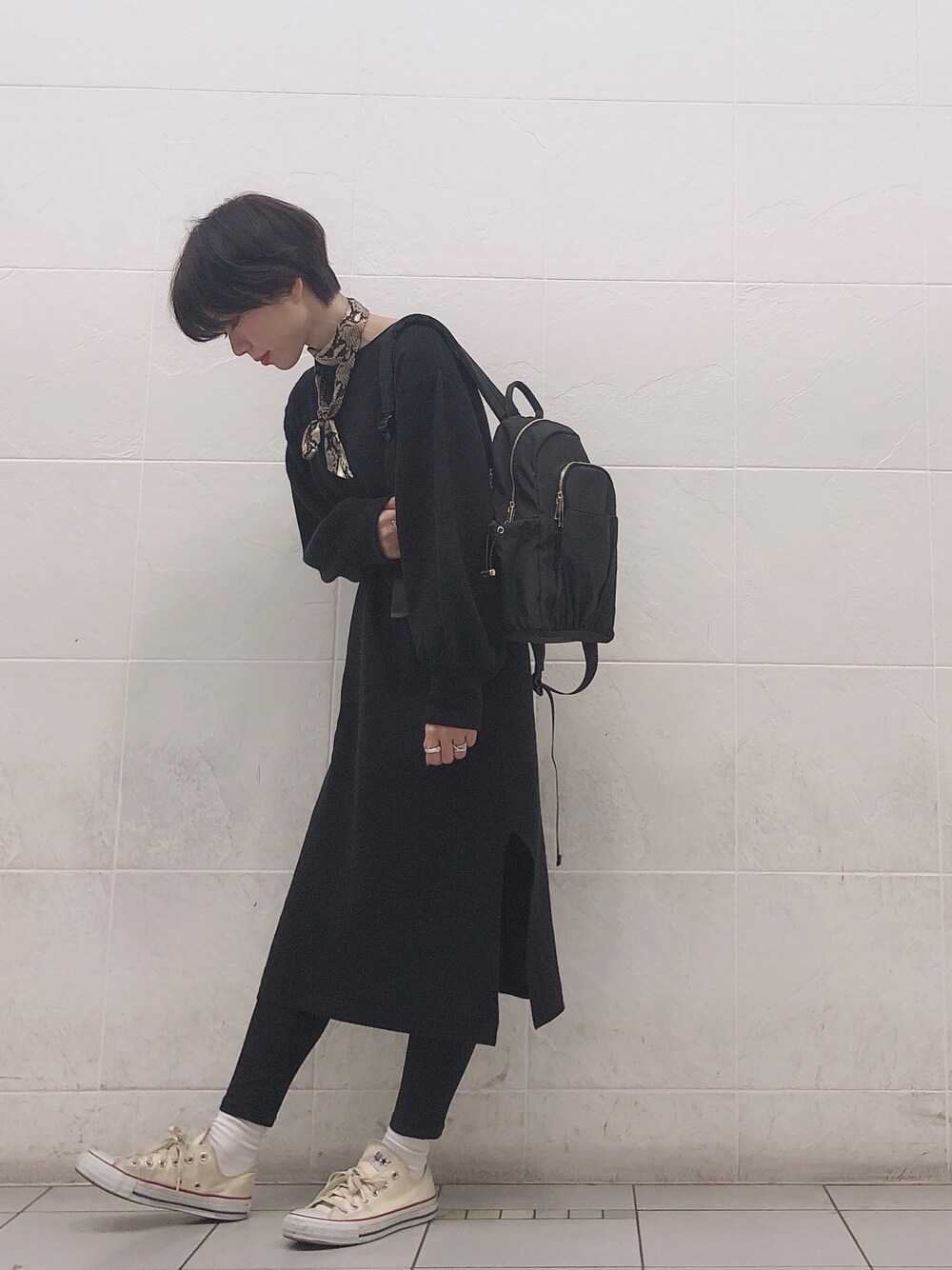 ブラック系のワンピース、ブラック系のバックパック/リュック、ブラック系のデニムパンツを着用したレディースの冬コーディネートの1枚目の写真