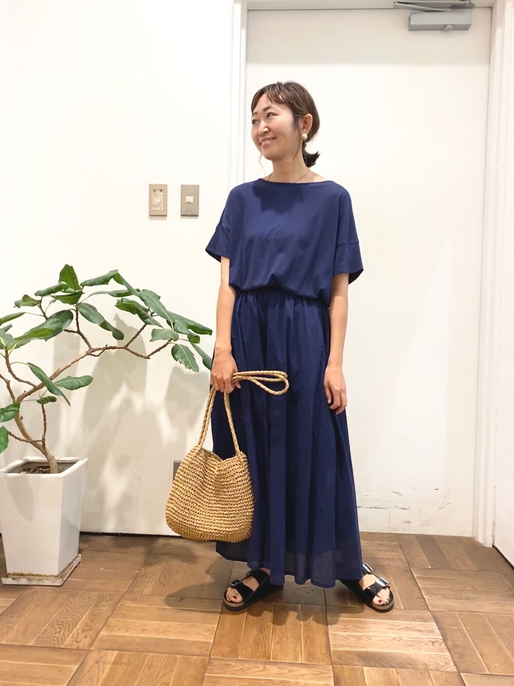 ブルー系のワンピース、ベージュ系のショルダーバッグ、ブラック系のサンダルを着用したレディースの夏コーディネートの1枚目の写真