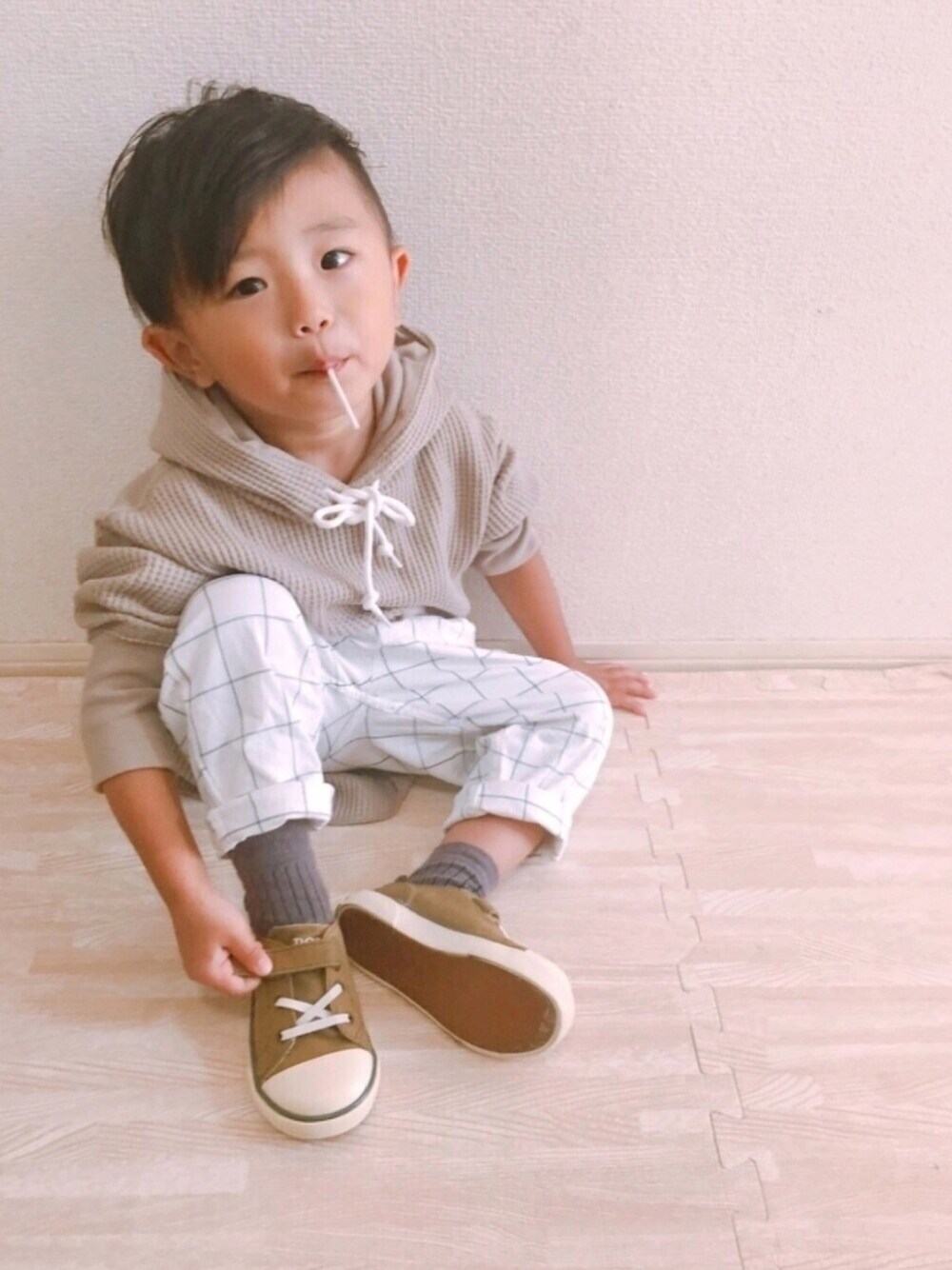 ベージュ系のパーカー、ホワイト系のその他パンツ、ベージュ系のスニーカーを着用したキッズの秋コーディネートの1枚目の写真