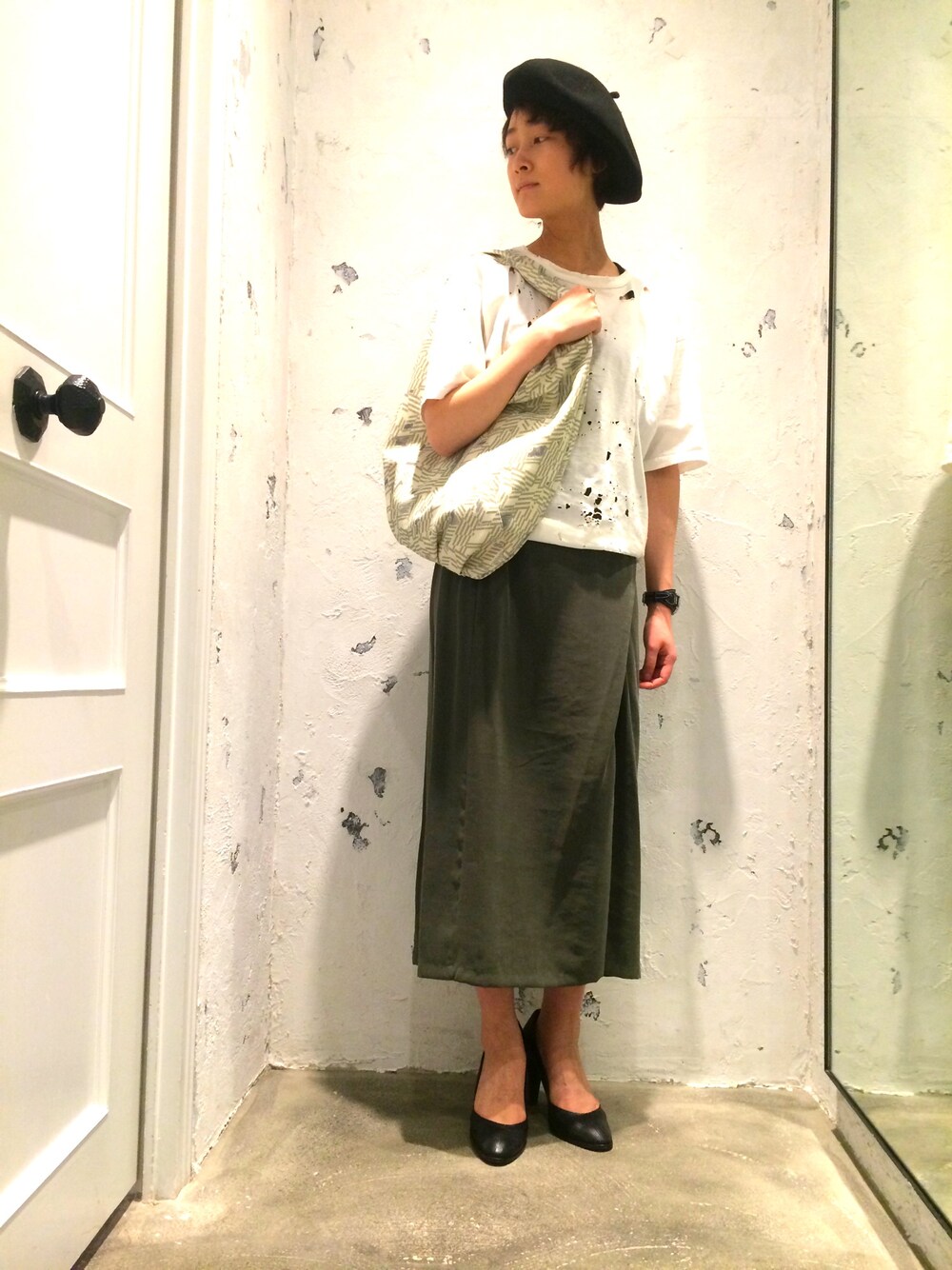 グリーン系のスカート、ホワイト系のTシャツ/カットソー、グリーン系のトートバッグを着用したレディースの冬コーディネートの1枚目の写真