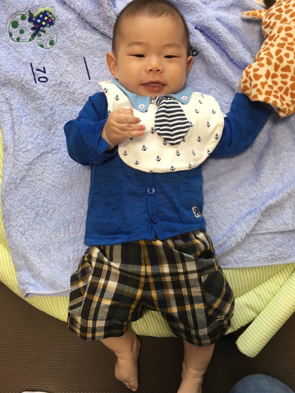 「男の子、おでかけ、カーディガン、青、チェックパンツ、ネクタイ、スタイ、銀座、よそいき、生後4ヶ月」｜「motherwaysのベビーボーイズ　プレミアム　ネクタイ&蝶ネクタイ衿付　ビブ　2枚組　《motherways｜マザウェイズ》（スタイ/よだれかけ、ホワイト系）」を使った、りょーたんさん（キッズ・60cm）の春コーディネートの1枚目の写真