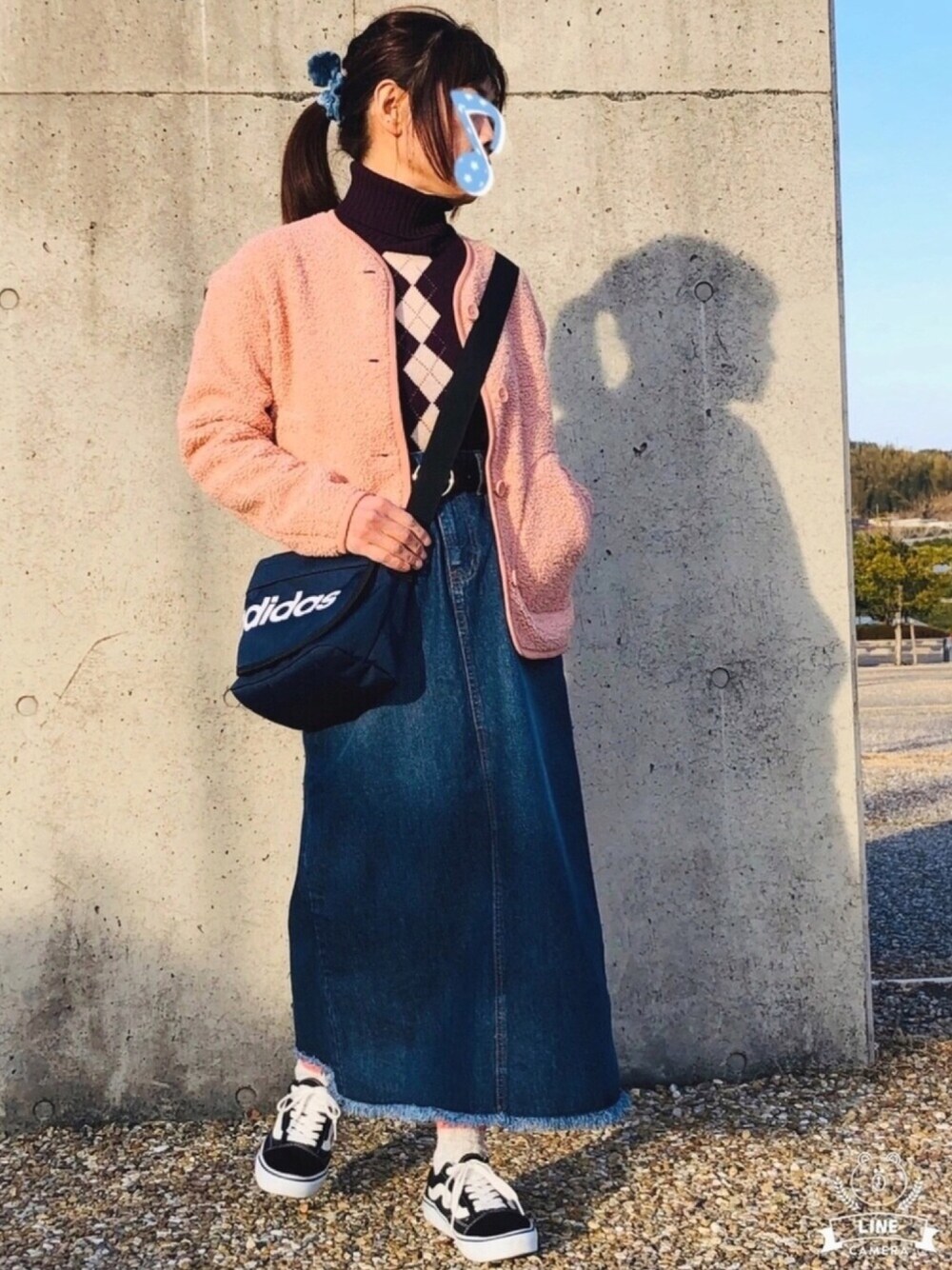 パープル系のニット/セーター、ピンク系のノーカラージャケット、ブルー系のデニムスカートを着用したレディースの冬コーディネートの1枚目の写真