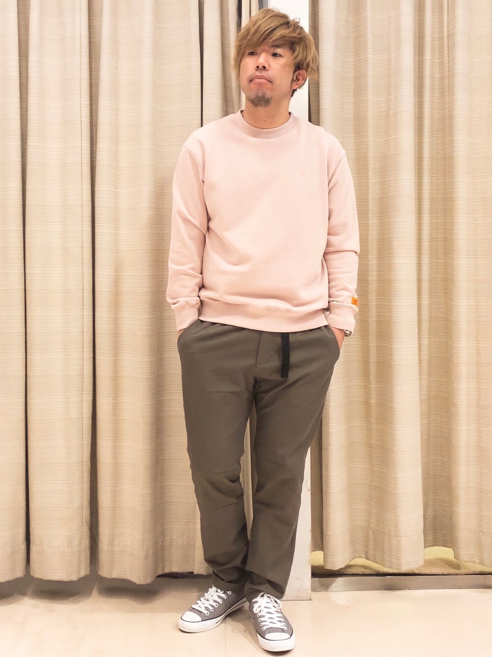 ピンク系のスウェット、グリーン系のその他パンツ、グレー系のスニーカーを着用したメンズの春コーディネートの1枚目の写真