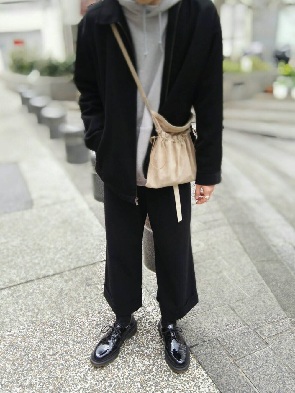 ベージュ系のボディバッグ/ウエストポーチ、グレー系のパーカー、ブラック系のドレスシューズを着用したメンズの春コーディネートの1枚目の写真