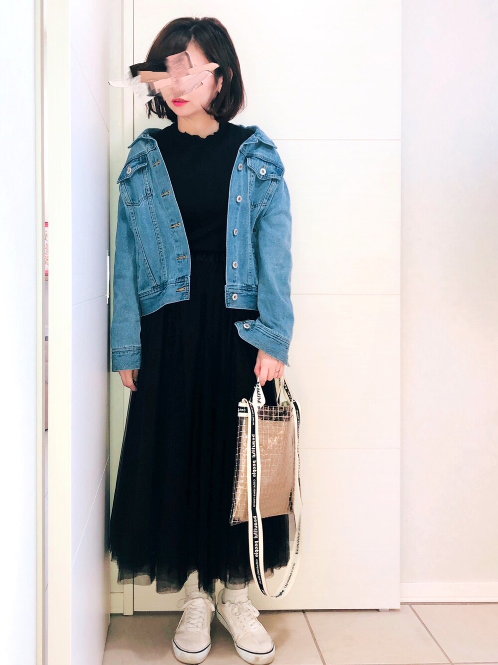 ブルー系のデニムジャケット、ブラック系のスカート、ホワイト系のスニーカーを着用したレディースの冬コーディネートの1枚目の写真