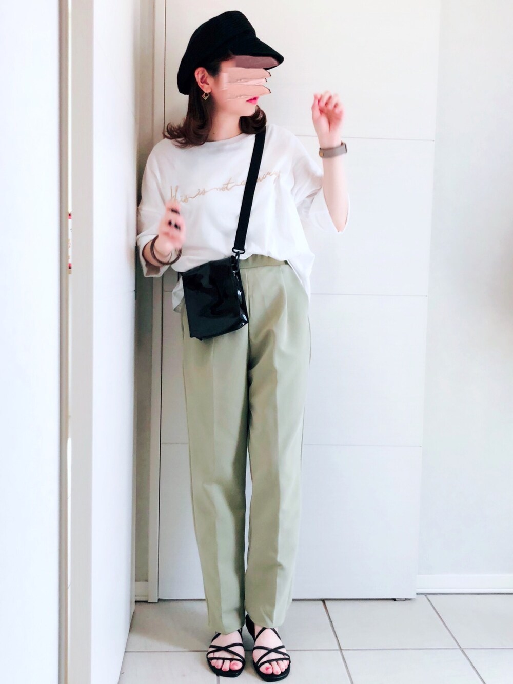 ホワイト系のTシャツ/カットソー、グリーン系のスラックス、ブラック系のサンダルを着用したレディースの夏コーディネートの1枚目の写真