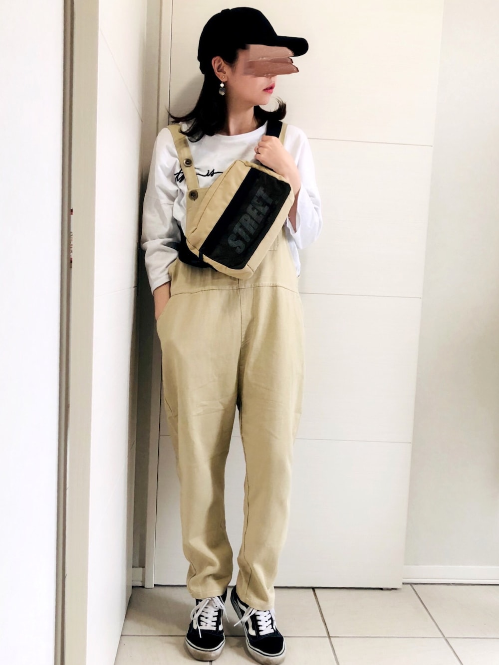 ホワイト系のTシャツ/カットソー、ベージュ系のサロペット/オーバーオール、ブラック系のスニーカーを着用したレディースの夏コーディネートの1枚目の写真