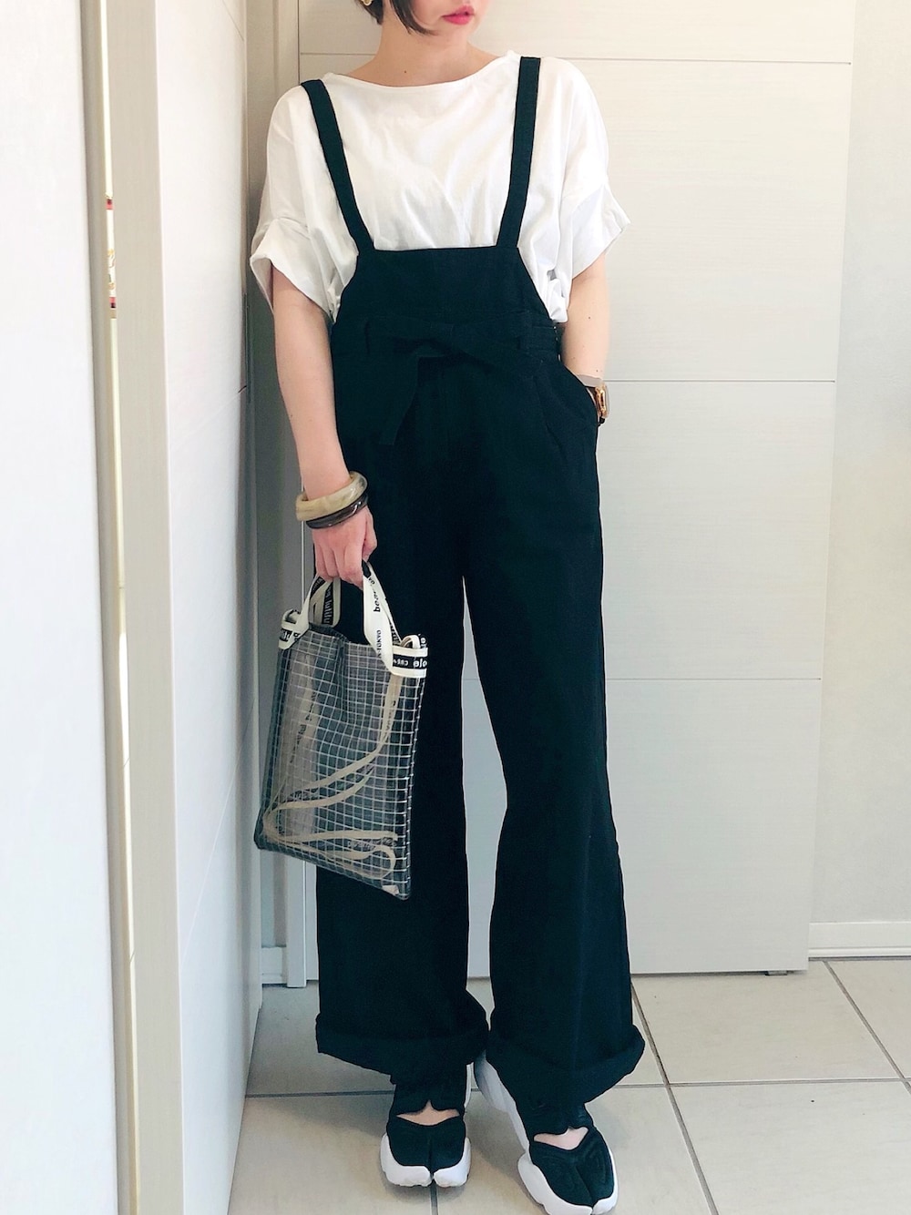 ホワイト系のTシャツ/カットソー、ブラック系のサロペット/オーバーオール、ブラック系のスニーカーを着用したレディースの夏コーディネートの1枚目の写真